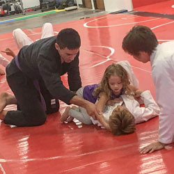 Coach Ty strang teahces a kids BJJ class at Aces Jiu Jitsu Club